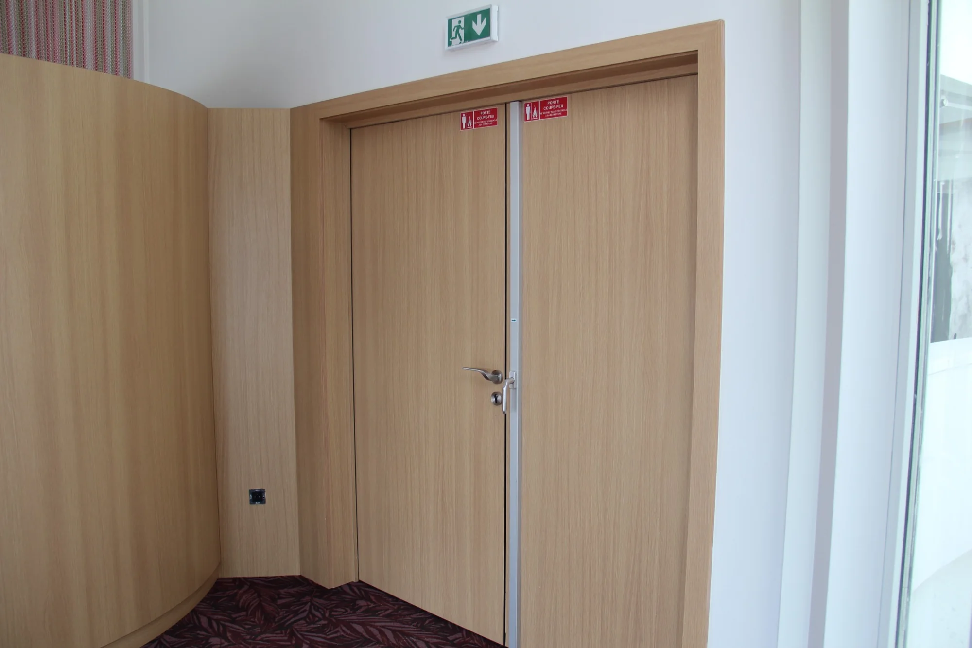 Portes coupe-feu finition bois clair au Royal Palace