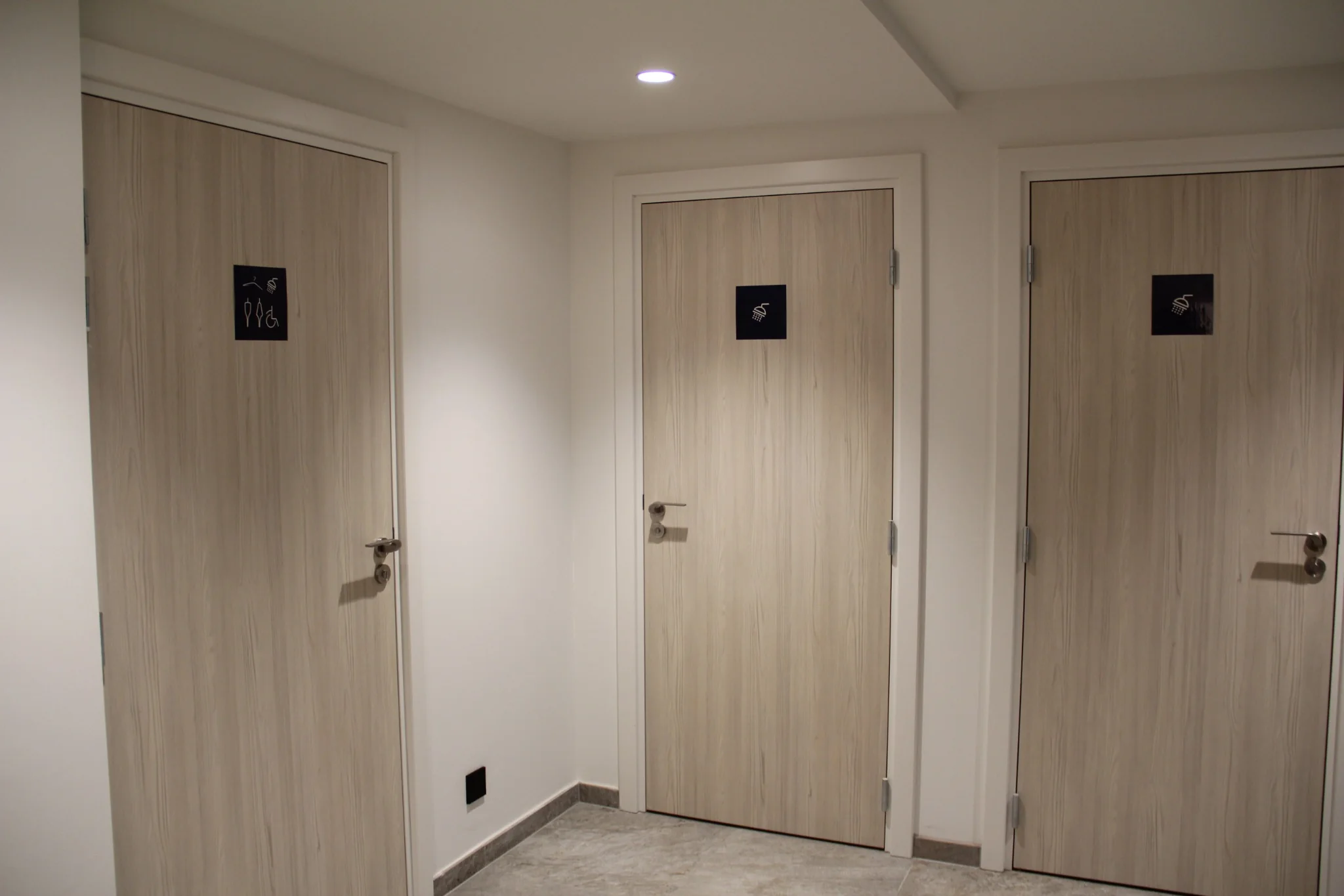 Alignement de portes bois clair dans les vestiaires du Royal Palace